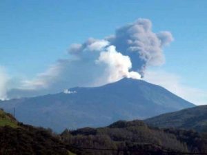a large plume of smoke rising from a mountain.