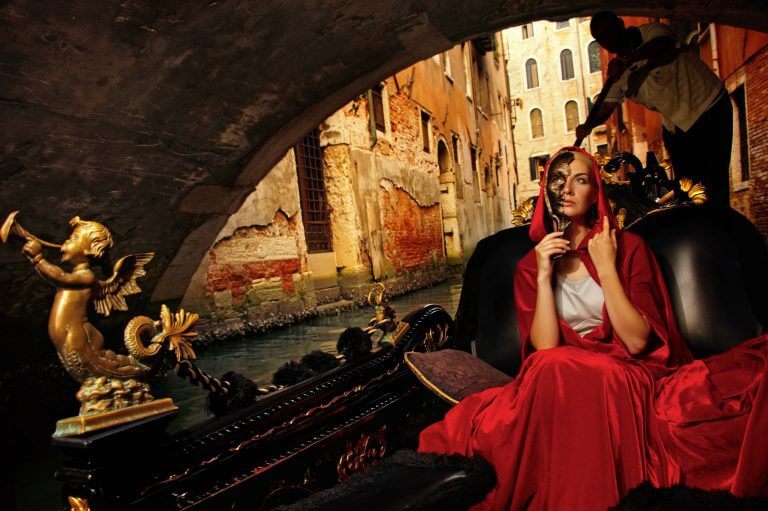 Beautifiul woman in red cloak riding on gandola